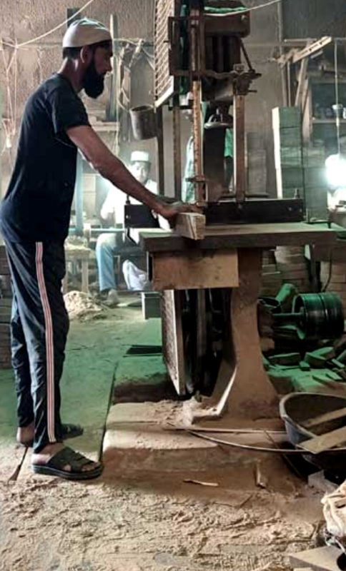 A man working on wood in a wooden factory of crafts work store